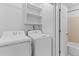Laundry room including washer, dryer, and storage shelving at 2568 Redfield Dr, Norcross, GA 30071