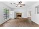 Inviting living room featuring wood floors, a stone fireplace, abundant natural light, and neutral walls at 2568 Redfield Dr, Norcross, GA 30071
