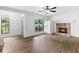 Cozy living room with a stone fireplace, wood floors, and large windows for ample natural light at 2568 Redfield Dr, Norcross, GA 30071