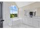 Luxurious bathroom boasting a soaking tub, glass shower, and a large arched window at 3226 Masters Pass Ln, Snellville, GA 30039