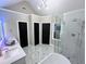 Bathroom with a double vanity, glass shower, soaking tub, and three black paneled doors at 3226 Masters Pass Ln, Snellville, GA 30039