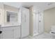 Bright bathroom with a glass shower, a vanity, and a storage cabinet at 3226 Masters Pass Ln, Snellville, GA 30039