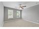 Neutral bedroom with two large windows, a ceiling fan, and carpeted floors at 3226 Masters Pass Ln, Snellville, GA 30039