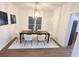 Bright dining room featuring modern chandelier, wood floors, and white chairs at 3226 Masters Pass Ln, Snellville, GA 30039
