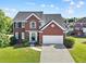 Charming two-story red brick home with a two-car garage and well-manicured lawn at 3226 Masters Pass Ln, Snellville, GA 30039