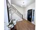 Welcoming foyer with wood floors, staircase, modern light fixture, and front door at 3226 Masters Pass Ln, Snellville, GA 30039