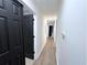Bright hallway featuring hardwood floors and stylish black doors at 3226 Masters Pass Ln, Snellville, GA 30039