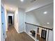 Hallway with wood floors and black metal railing at 3226 Masters Pass Ln, Snellville, GA 30039