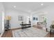 Open-concept living room with a glass desk, hardwood floors, and elegant decor at 3226 Masters Pass Ln, Snellville, GA 30039