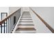 Stairway with wood treads, white risers, and black metal railing at 3226 Masters Pass Ln, Snellville, GA 30039