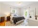Bright bedroom with hardwood floors, a ceiling fan, large windows with curtains, and a comfortable bed at 67 Trammell Sw St, Marietta, GA 30064