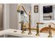 Close up of a kitchen sink with a stylish brass faucet and white countertop, offering a modern and elegant design at 67 Trammell Sw St, Marietta, GA 30064