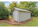 Exterior view of a shed in a backyard, providing additional storage space, surrounded by trees and lawn at 67 Trammell Sw St, Marietta, GA 30064