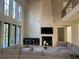 Elegant living room featuring a fireplace, TV, high ceilings, and a comfortable sectional sofa at 1303 Cobblemill Nw Way, Kennesaw, GA 30152