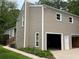 Exterior showing a two-story home with a two-car garage, complemented by green grass and mature trees at 3100 Karen Ne Ln, Marietta, GA 30062