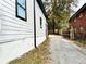 Side view of a home showing the new siding, trim, and a driveway leading to a fenced backyard at 701 Cameron M Alexander Nw Blvd, Atlanta, GA 30318