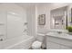 Bright bathroom featuring a white tub with shelving, toilet, and a vanity with a marble countertop and decorative art at 1315 Aura Ln, Lawrenceville, GA 30045
