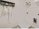 The laundry room includes a white tile floor, shelves, hooks, and wall-mounted fixtures and connections at 1315 Aura Ln, Lawrenceville, GA 30045