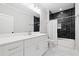 Modern bathroom with black tiled shower, white vanity, and patterned tile flooring at 313 Sisson Ne Ave, Atlanta, GA 30317
