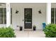 Inviting front porch with elegant black door, sconces, and potted plants at 313 Sisson Ne Ave, Atlanta, GA 30317