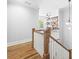 Upstairs hallway featuring hardwood floors, shiplap wall and built in bookshelves in adjacent room at 313 Sisson Ne Ave, Atlanta, GA 30317