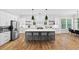 Open-concept kitchen featuring white cabinets, a gray island, and modern pendant lighting at 313 Sisson Ne Ave, Atlanta, GA 30317
