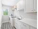 Bright laundry room with white cabinets, modern washer/dryer, and stylish patterned flooring at 313 Sisson Ne Ave, Atlanta, GA 30317