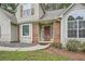 Inviting front entryway with red brick accents, a modern front door, and a well-maintained walkway at 3404 Bodiford Path Path, Powder Springs, GA 30127