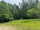 A grassy backyard shows a storage shed and some sparse trees at 361 West Ave, Dallas, GA 30157