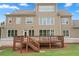 Rear view of a well-maintained home with a deck, multiple windows, and manicured lawn at 4530 Westgate Dr, Cumming, GA 30040