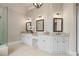 Bathroom featuring dual sinks with granite countertop, decorative mirrors, and walk-in shower at 4530 Westgate Dr, Cumming, GA 30040