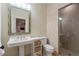 Elegant bathroom featuring a pedestal sink, decorative mirror, and tiled walk-in shower at 4530 Westgate Dr, Cumming, GA 30040