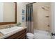 Bathroom with granite countertop, framed mirror, and tiled shower/tub with a decorative shower curtain at 4530 Westgate Dr, Cumming, GA 30040