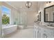 Bathroom with dual sinks, free-standing tub, walk-in shower, and large window at 4530 Westgate Dr, Cumming, GA 30040