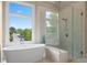 Bathroom featuring a soaking tub, walk-in shower, bench seat, and large window at 4530 Westgate Dr, Cumming, GA 30040