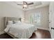 Bright bedroom featuring tray ceilings, a ceiling fan, hardwood floors and shuttered windows at 4530 Westgate Dr, Cumming, GA 30040