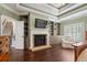 Bedroom with fireplace, built-in shelving, plantation shutters, and hardwood floors at 4530 Westgate Dr, Cumming, GA 30040