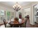 Dining room featuring hardwood floors, chandelier, and plantation shutters at 4530 Westgate Dr, Cumming, GA 30040