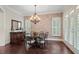 Dining room with brick accent wall, chandelier, buffet, and shutters at 4530 Westgate Dr, Cumming, GA 30040