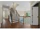 A staircase with wrought iron railing and hardwood floors is illuminated by a window and chandelier at 4530 Westgate Dr, Cumming, GA 30040