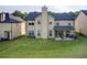 Back exterior view of the home overlooking a large, grassy backyard and an outdoor patio at 3746 Okefenokee Rdg, Loganville, GA 30052