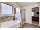 Bright bathroom with a glass shower, soaking tub, and a window for natural light at 3746 Okefenokee Rdg, Loganville, GA 30052