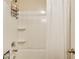 Clean, standard bathroom with white shower-tub, shower curtain, and shelving unit at 3746 Okefenokee Rdg, Loganville, GA 30052