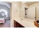 Bright bathroom with a single sink vanity, light walls and views into the bedroom at 3746 Okefenokee Rdg, Loganville, GA 30052