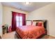 Cozy bedroom with a patterned comforter, plush pillows, and natural light streaming through the window at 3746 Okefenokee Rdg, Loganville, GA 30052