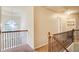 Upstairs hallway with wood and iron railing, large arched window, and access to laundry room and other rooms at 3746 Okefenokee Rdg, Loganville, GA 30052