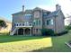 Rear of a brick home with a deck and patio, overlooking a large backyard at 1241 Edgebrook Ln, Snellville, GA 30078