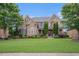 Charming brick home featuring lush green lawns, mature trees, and architectural details at 1241 Edgebrook Ln, Snellville, GA 30078