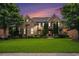 Charming brick home featuring lush green lawns, mature trees, and architectural details at sunset at 1241 Edgebrook Ln, Snellville, GA 30078