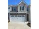 Charming two-story townhome featuring a stone facade and a spacious two-car garage at 1311 Aura Ln, Lawrenceville, GA 30045